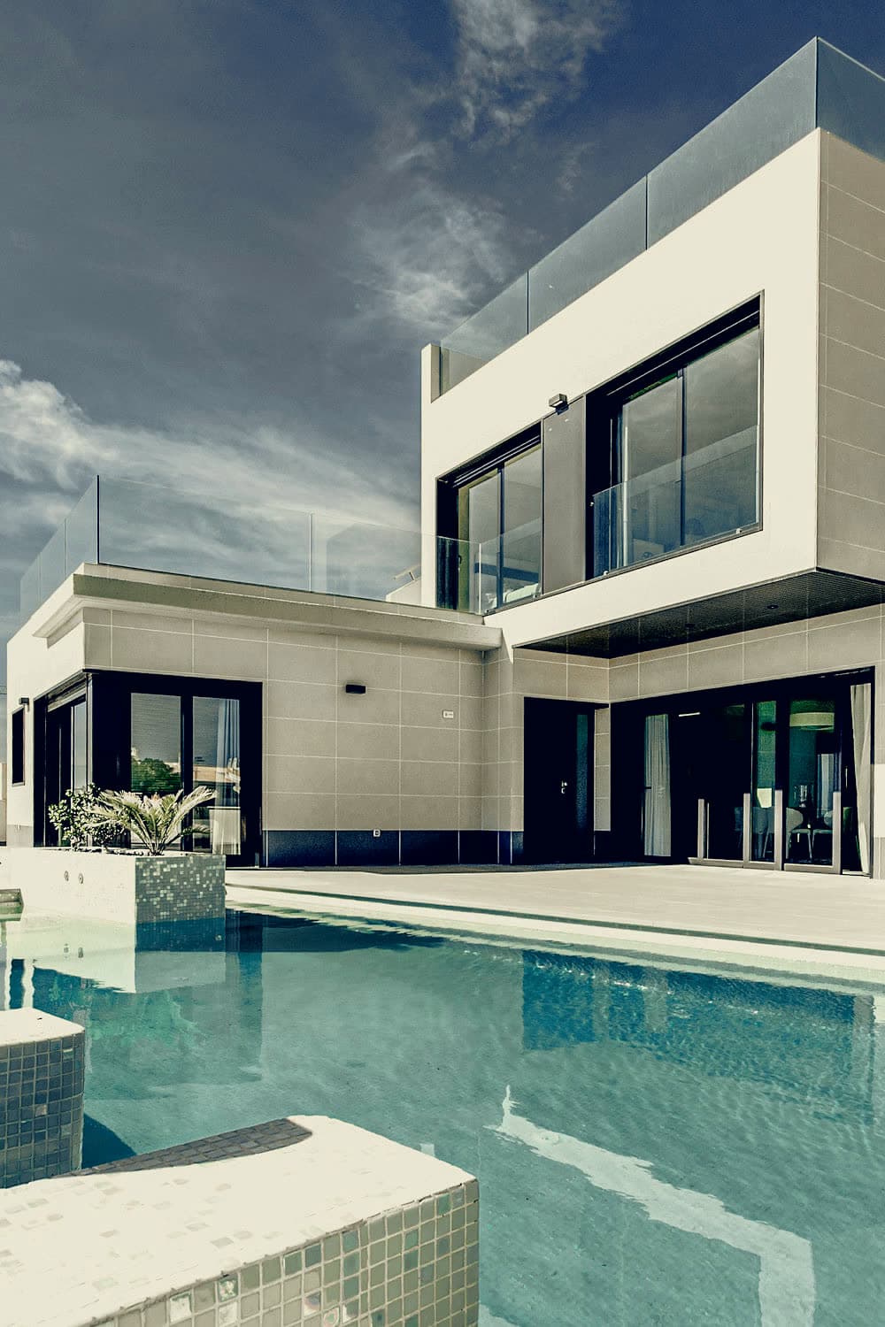 Stacked white villa above a still pool
